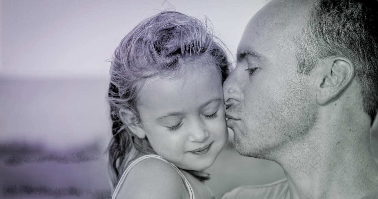 closeup of dad kissing his daughter on the cheek