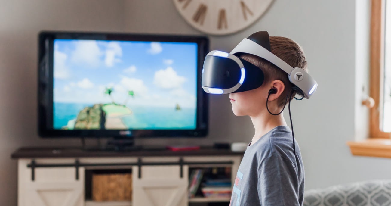 child with VR headset on in front of a TV